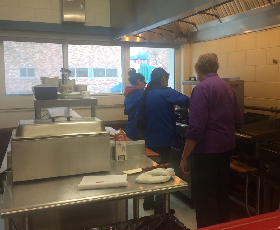 Diane Arifian teaches two students how to prepare pancakes.