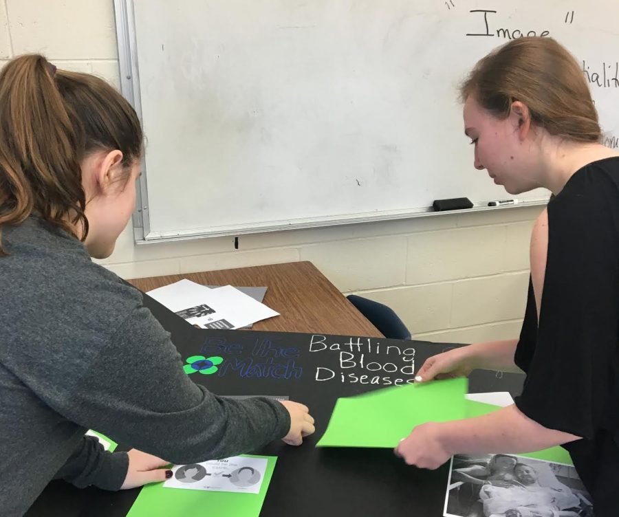 Anna Port, right, and Kim Meerman work on a poster for their Peer Leadership Community Change Project -- an event to find bone-marrow matches. 