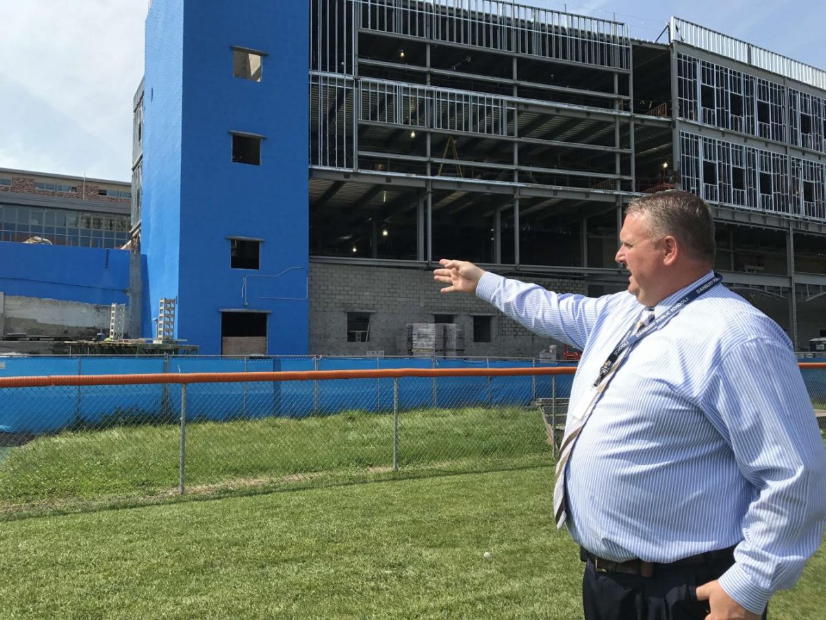 Principal Dan Donovan takes a reporter around on a tour of construction. Here, he is looking at the front of the new Freshman Academy.