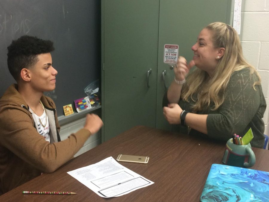Freshman Raudy Grullon signs with new ASL teacher Jessica Prunty. The course was revived after a years absence.