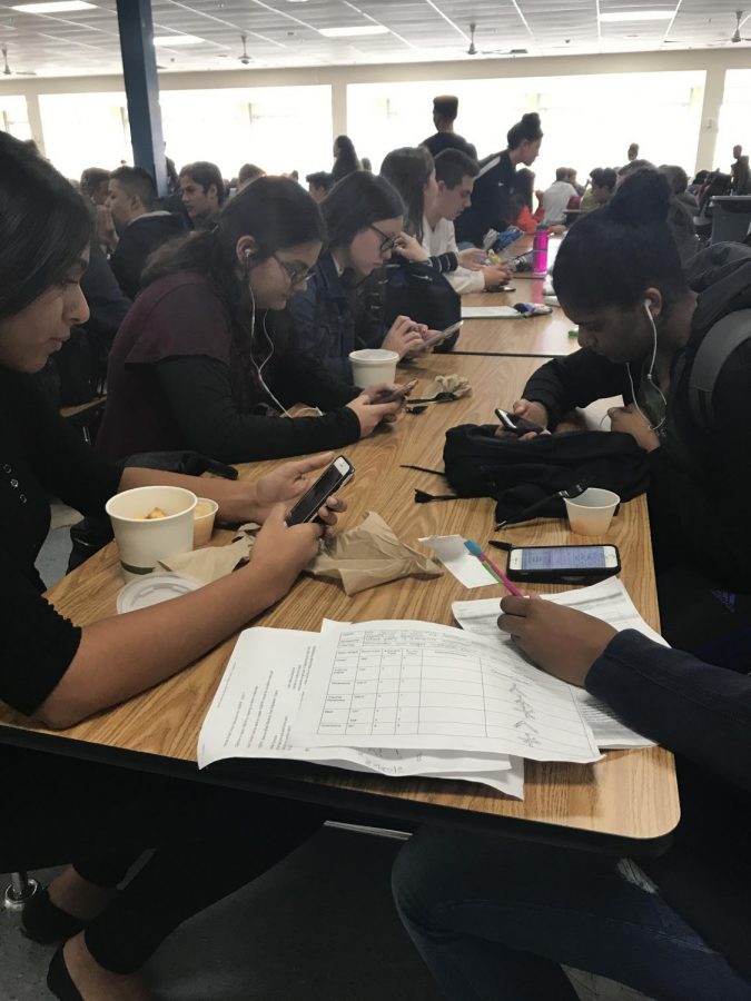 Students are seen using phones at lunch instead of talking with each other.