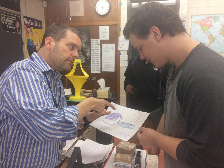 Physics teacher Jameson Parker works on a physics problem with Trevor Roos. Parker is up front with his students about Kennedys Disease and how it affects him.