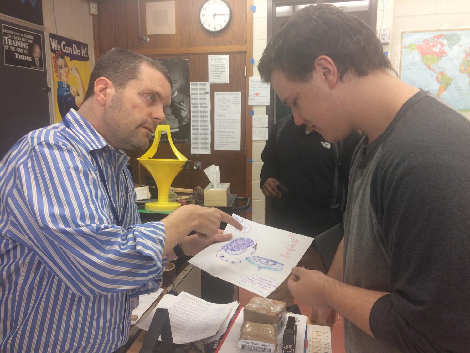 Physics teacher Jameson Parker works on a physics problem with Trevor Roos. Parker is up front with his students about Kennedy's Disease and how it affects him.