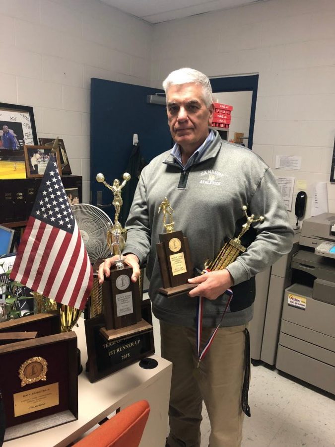 Athletics Director Chip Salvestrini shows some of the trophies won by DHS winter sports teams. 