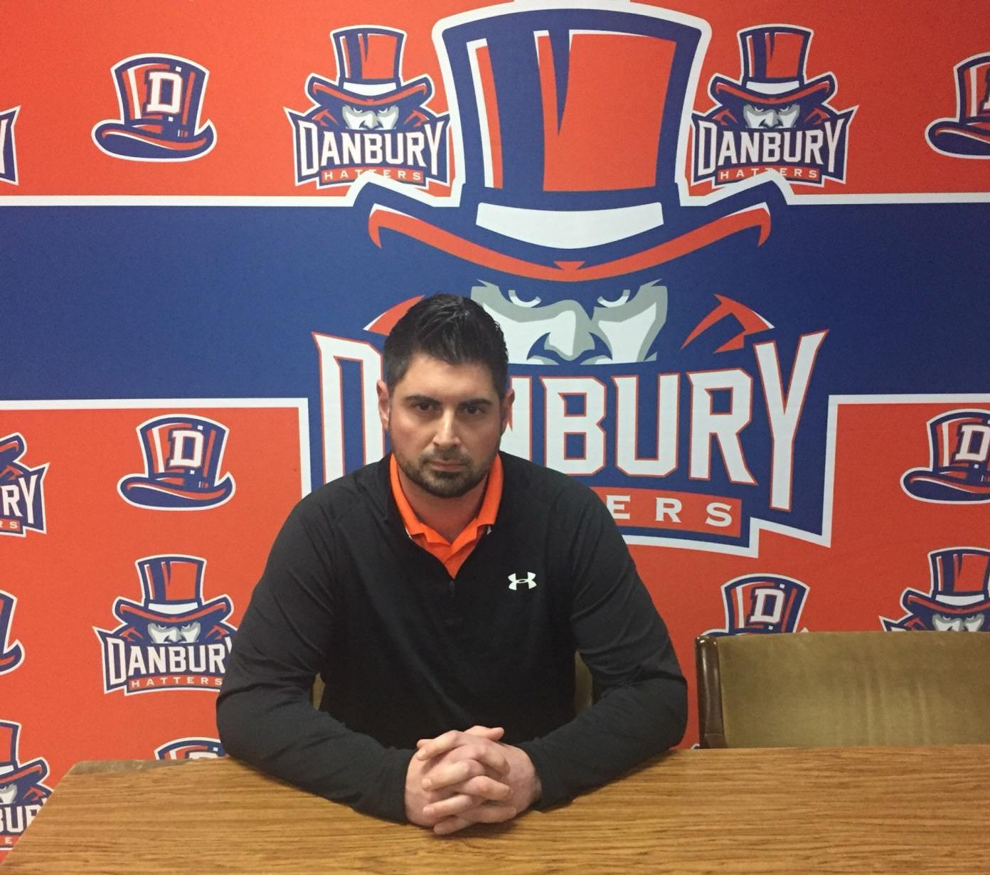 Coach Augustine Tieri sits in front of Danbury's new backdrop to meet with the press after it was announced today that he has been named head football coach.
