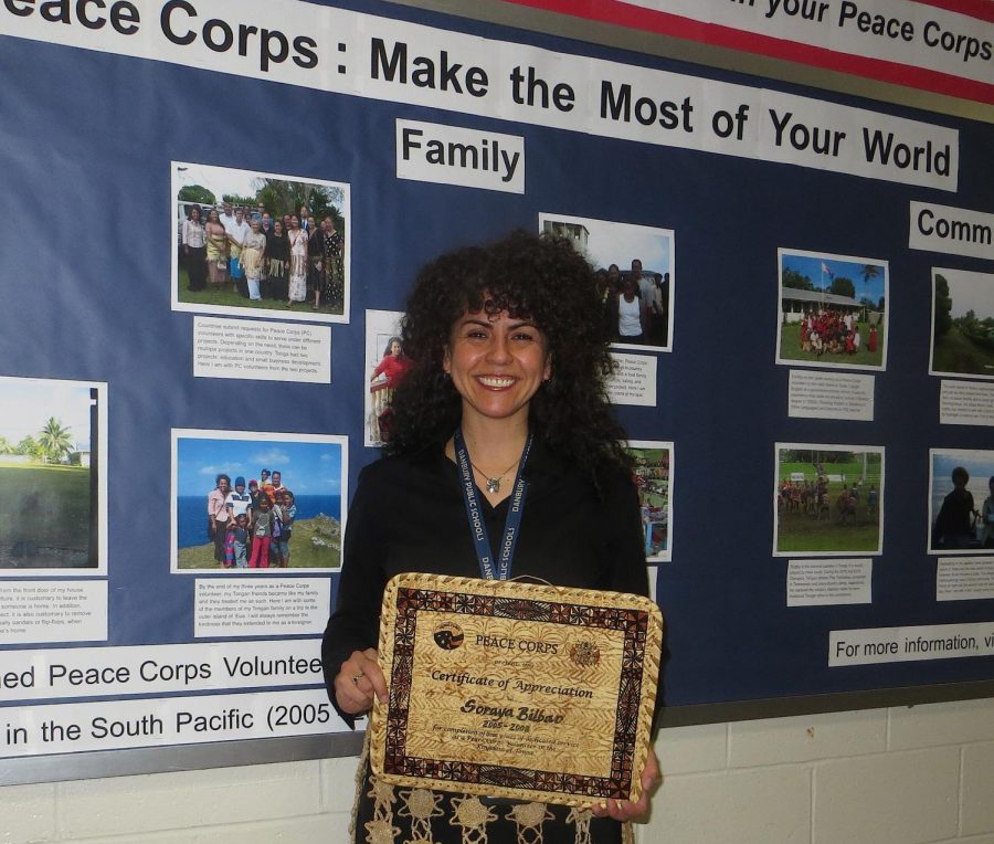 ESL teacher Soraya Bilbao stands before the bulletin board that she produced to commemorate Peace Corps Week. Bilbao presented to several classes about her own Peace Corps experience in the Kingdom of Tonga in the South Pacific.