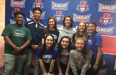 The 9 athlete signees stand together for a picture.