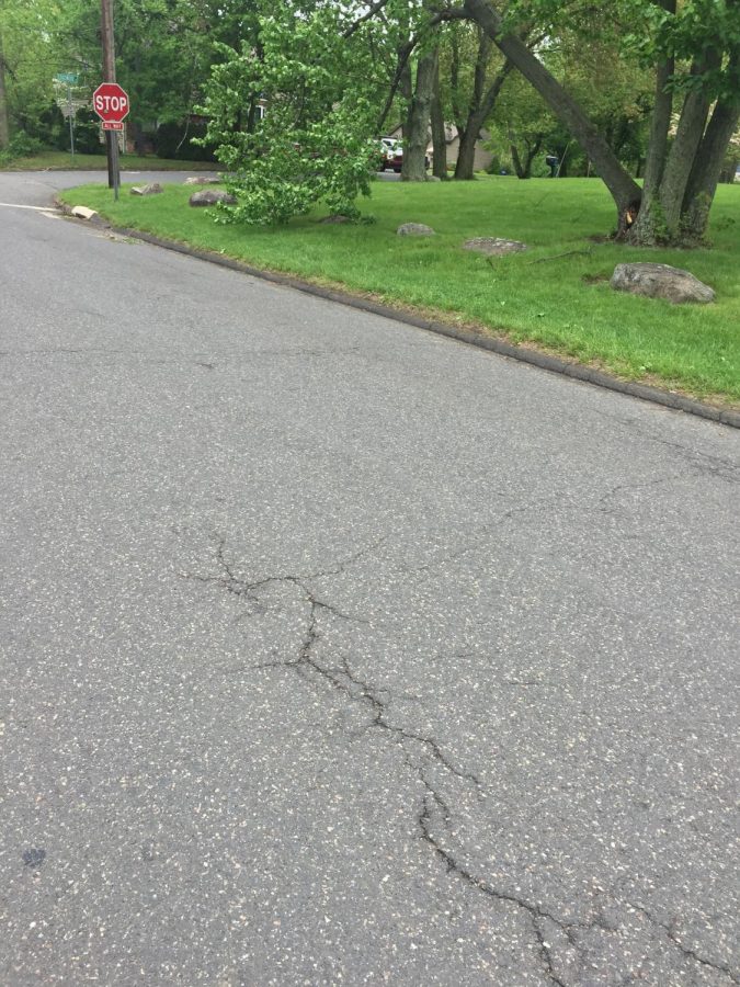 Damage on road caused by a downed live electrical wire.