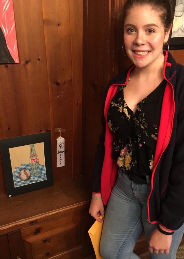 Sophomore Lindsey Bieber stands next to her artwork, 1931, which took third place at Richter’s 40th Annual Juried Art Show.