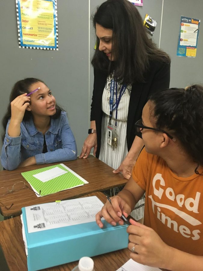 Nicole Martone works with two of her students recently in her AP English class. Martone was recently honored by Kappa Pi Delta.