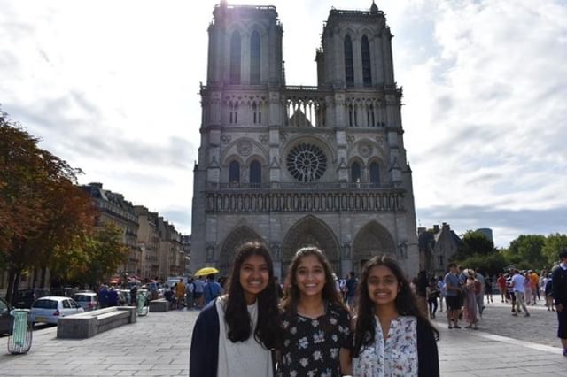 From left to right, Hope Thomas, Faith Thomas, and Rachel Thomas stand in front of the western facade of the Notre Dame Cathedral in Paris during their family vacation to Europe. 