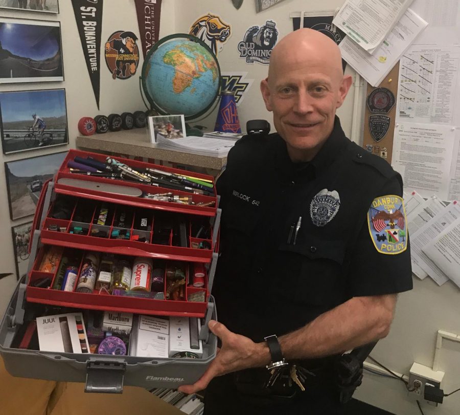 Officer+Morlock+stands+with+the+collection+of+vapes%2C+wax+pens%2C+pods%2C+juices%2C+carts%2C+and+even+cigarettes+that+hes+accumulated+over+his+years+at+DHS.+Although+when+any+one+of+these+items+is+found+on+a+student+it+is+considered+evidence+to+the+police%2C+everything+seen+here+he+has+simply+found+throughout+the+school.