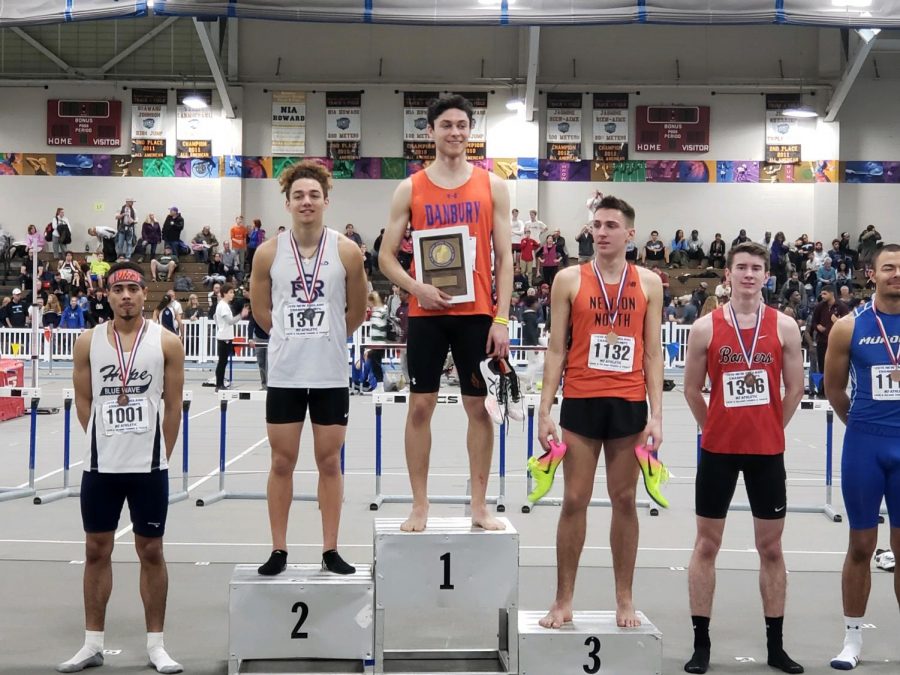 Senior track star Malcolm Going stands with pride after winning first place in the 600m during the indoor New England Championship in Boston on March 2. 