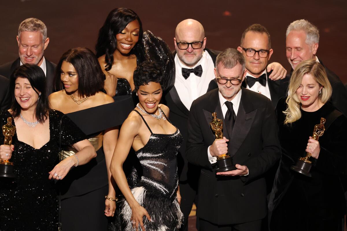 Director Paul Thomas Anderson and cast of One Battle After Another celebrate as they accept the Oscar for best picture.